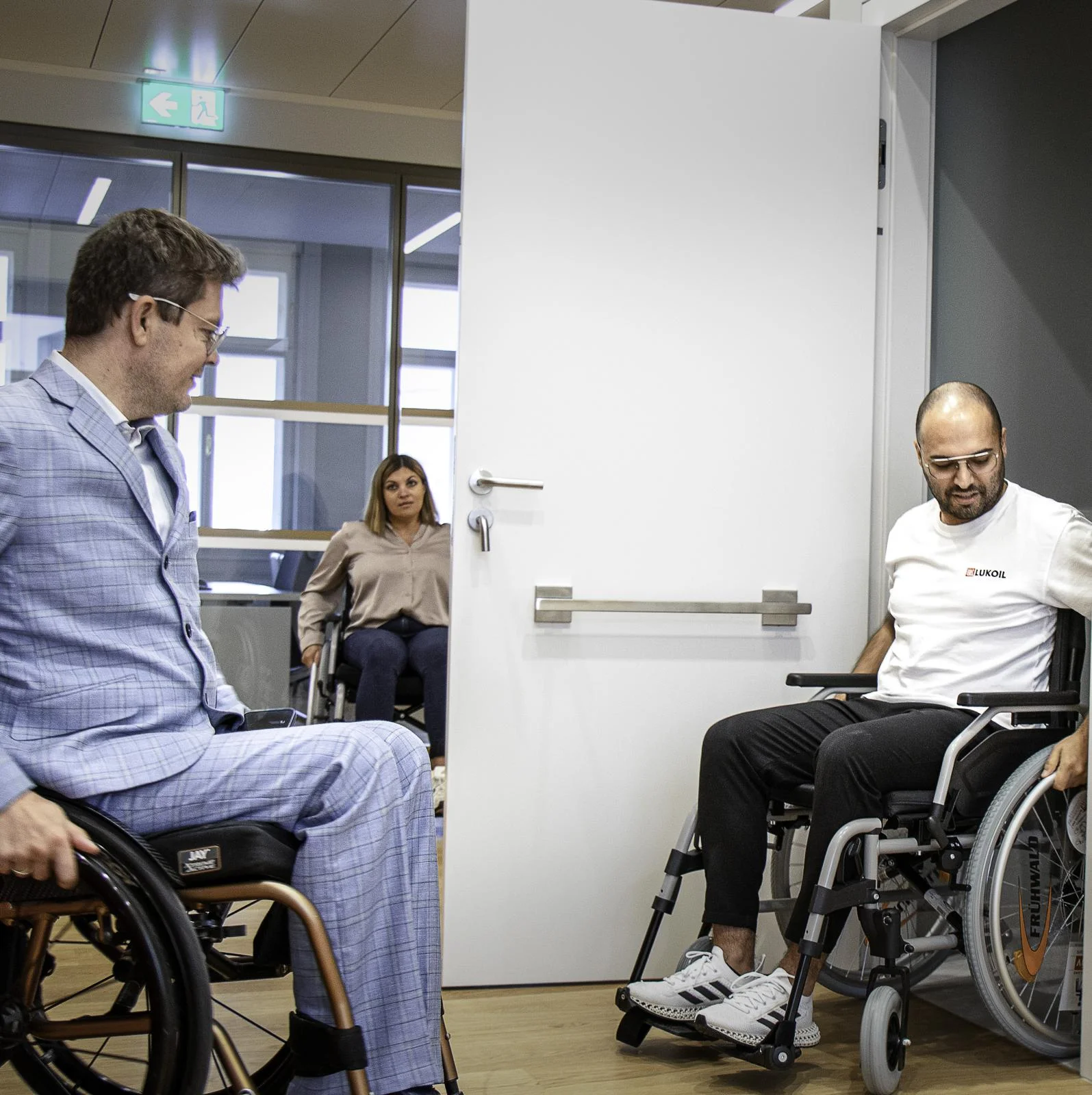 Teilnehmer*innen erproben mit Rollstühlen Barrieren an einer Tür
